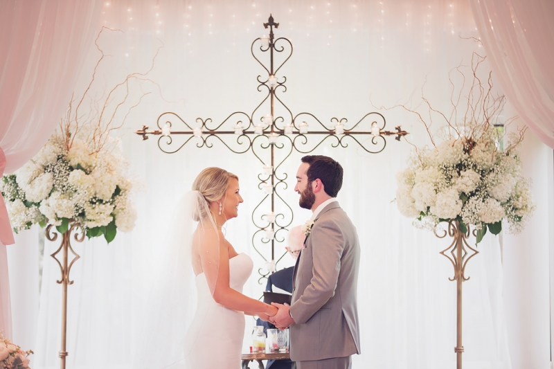 June indoor wedding with cross backdrop