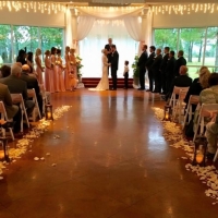 Saying I do at a wedding at House  Estate with rose petals and lantern aisle markers