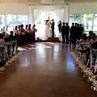Saying vows at an indoor wedding at House Estate with purple flower chair decor