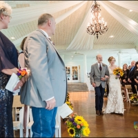 walking the aisle adorned with yellow sunflowers
