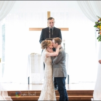 wedding kiss at the altar with color flower display