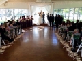 Saying vows at an indoor wedding at House Estate with purple flower chair decor