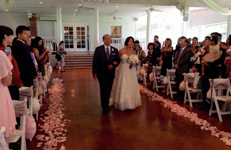 walking the aisle adorned with soft pink rose petals at House Estate