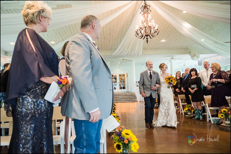 walking the aisle adorned with yellow sunflowers