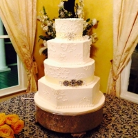 Four tiered elegant white wedding cake with neat topper