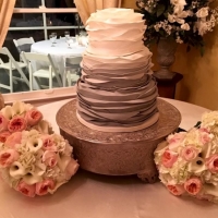 beautiful wedding cake with pastel colors surrounding it