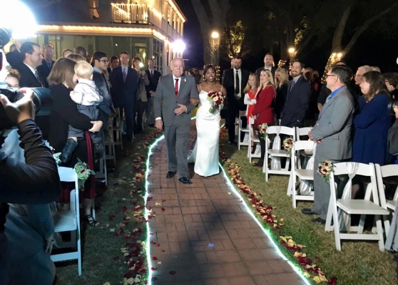 outdoor wedding in dec with walkway adorned with lights and rose petals
