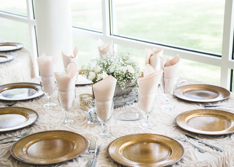 Reception table with light pinks, babies breath and gold buffers