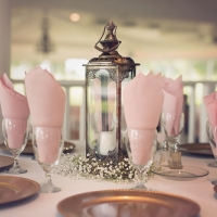 reception table with candles and lanterns and soft pink hues