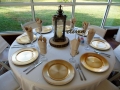 table settings with gold chargers and lantern centerpieces