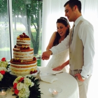 cutting the cake in June with a manicured outdoor view