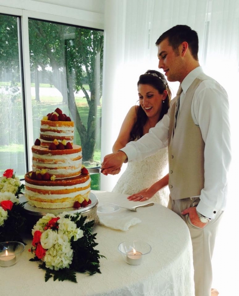 cutting the cake in June with a manicured outdoor view